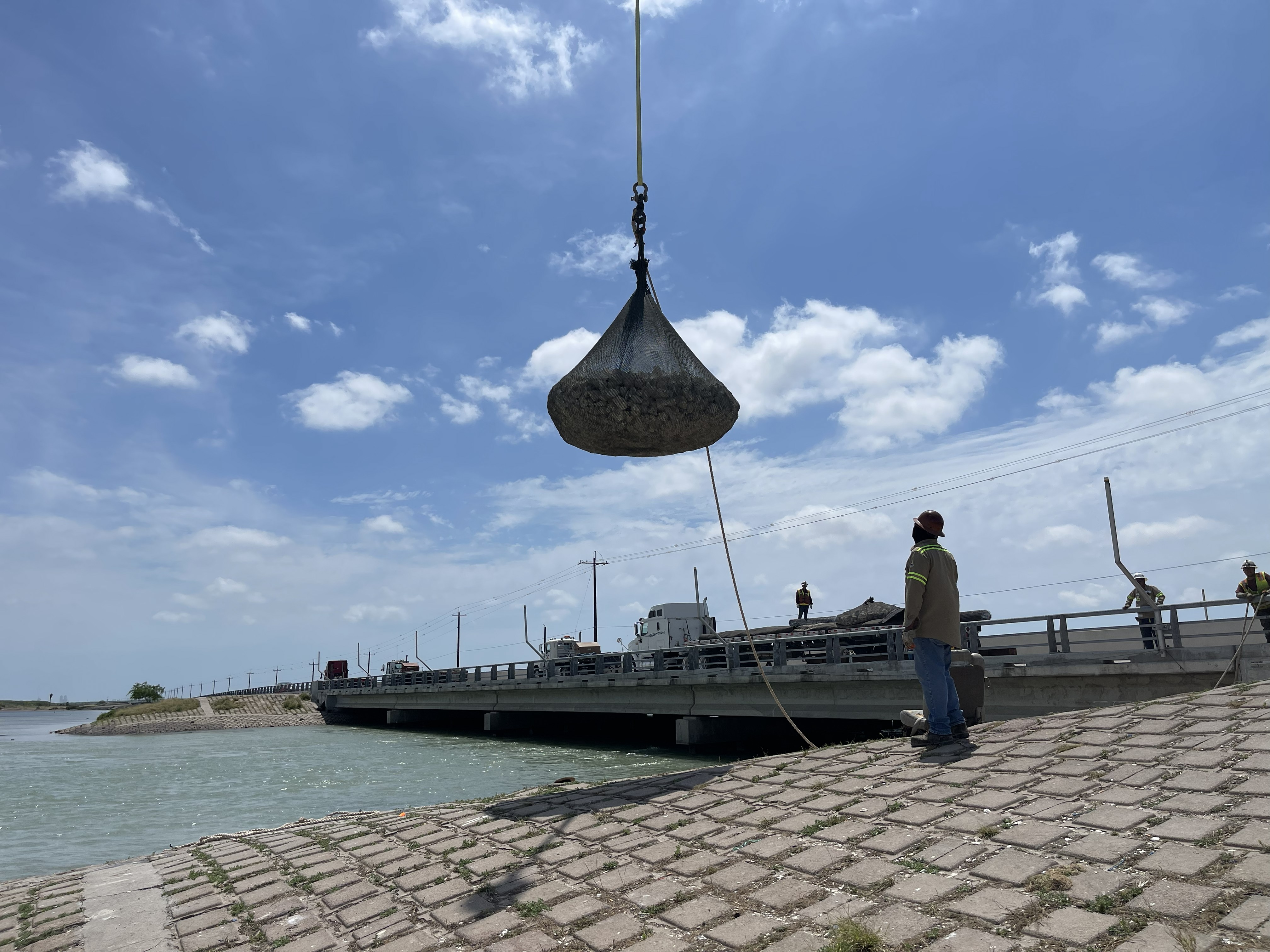 Riprap bags being placed for scour protection along a navigation channel